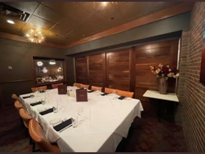 Well-appointed private dining room with a set table and sputnik chandelier.