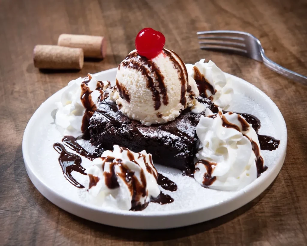 Brownie with vanilla ice cream, chocolate sauce, whipped cream, and maraschino cherry.