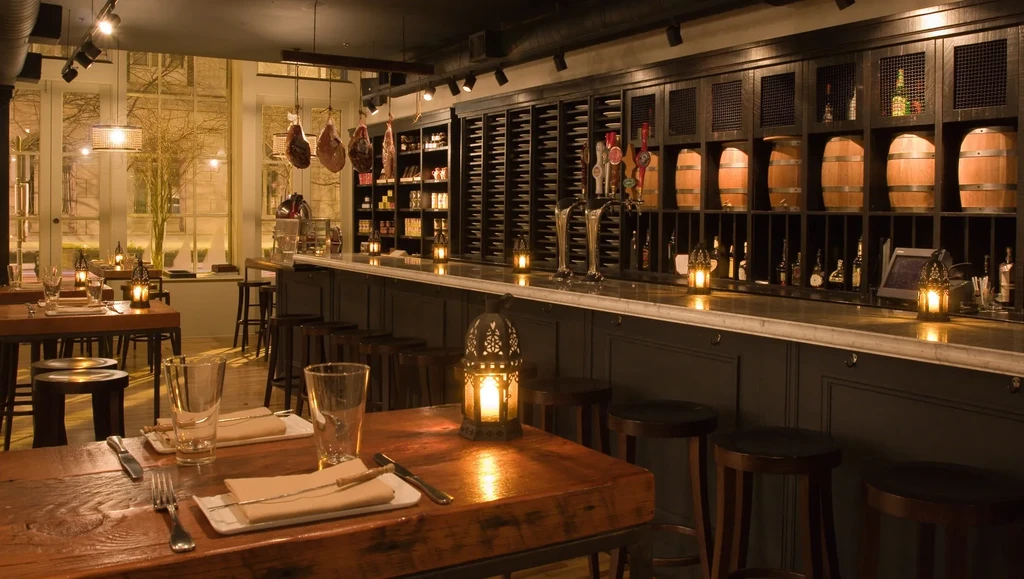 Sophisticated restaurant interior with a bar, tables, and warm lighting.