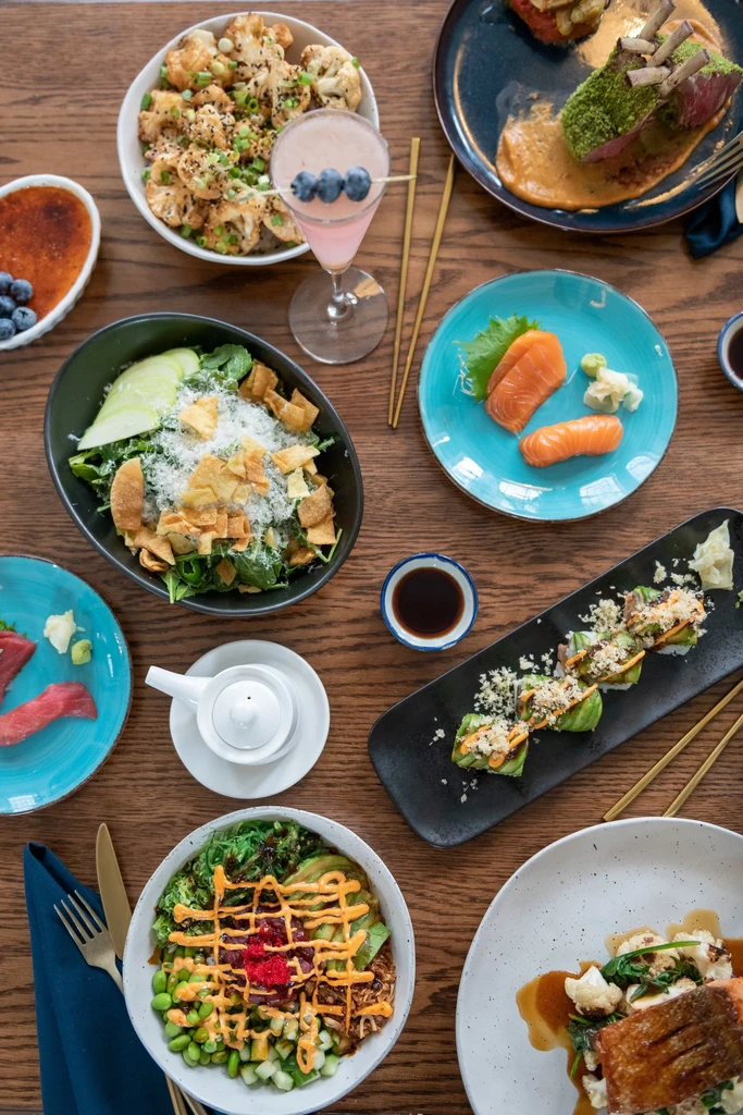 Overhead view of a wooden table laden with diverse gourmet dishes.
