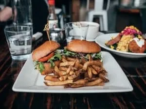 High-angle view of two burgers and fries on a restaurant table.