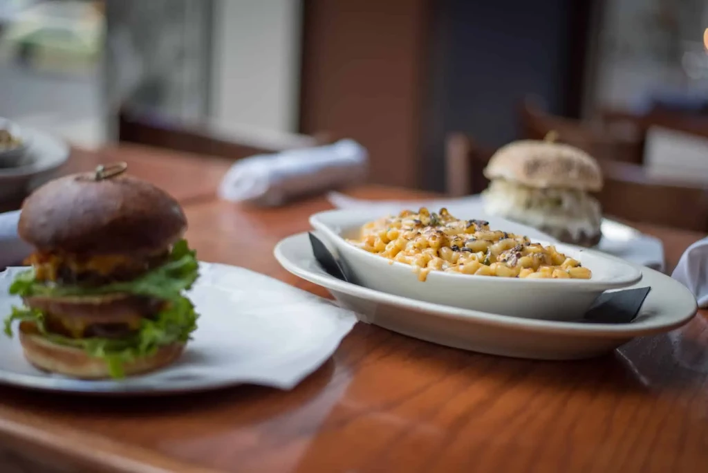 Skewered double burger and creamy mac and cheese on a table.