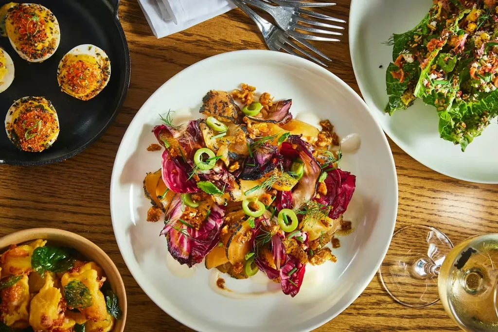 Overhead: dining table with gourmet dishes, deviled eggs, salads, and wine.