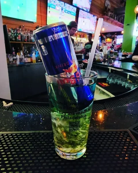 Blue Red Bull can inverted in green drink glass, Philadelphia text visible.