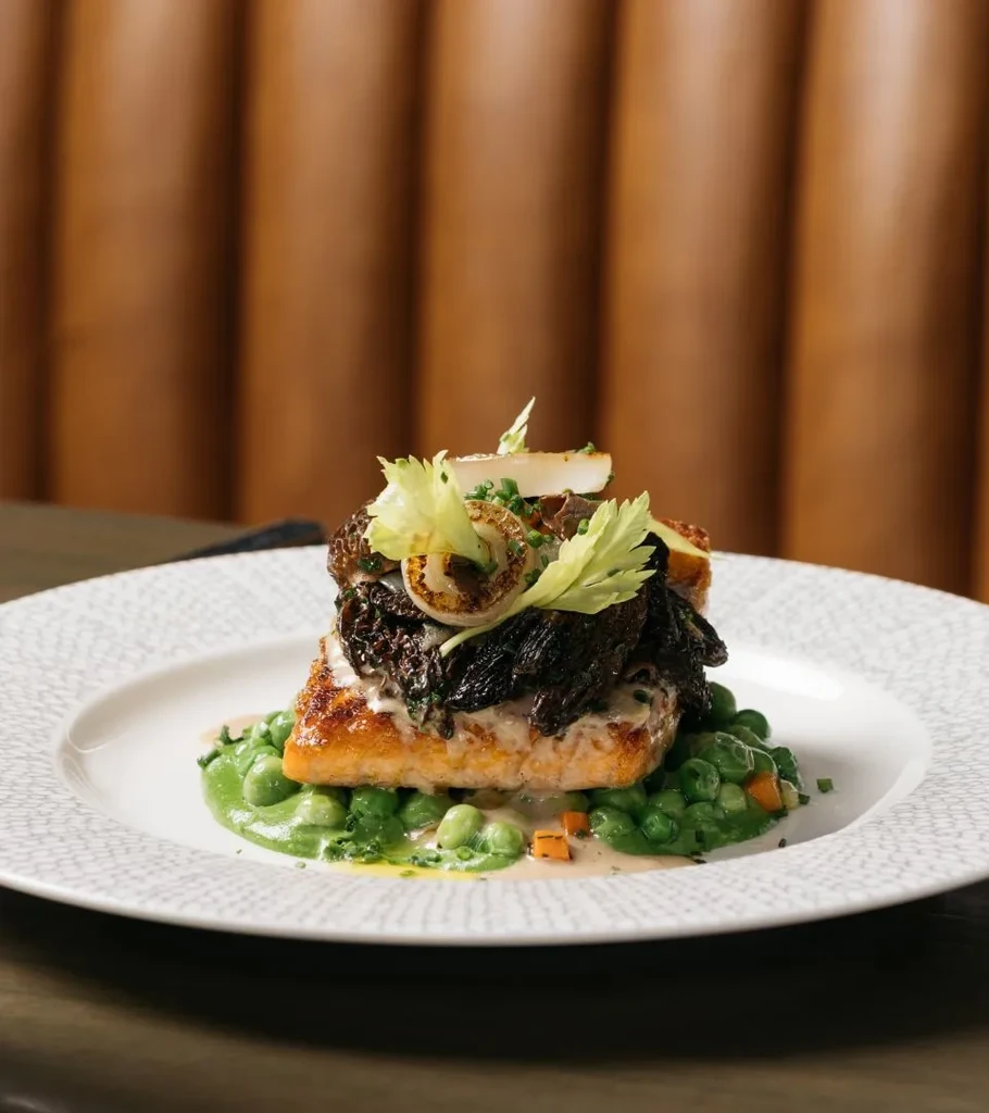 Pan-seared salmon with morel mushrooms, pea puree, and creamy sauce.