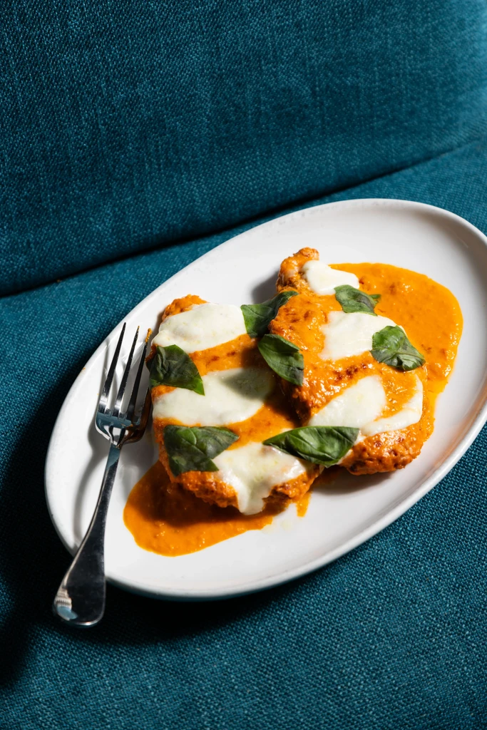 Breaded cutlets with orange-red sauce, melted mozzarella, and fresh basil.