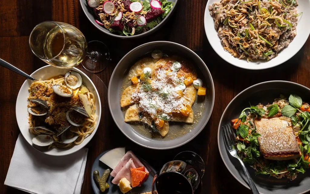 Overhead shot of a dining table with many professionally styled dishes and drinks.