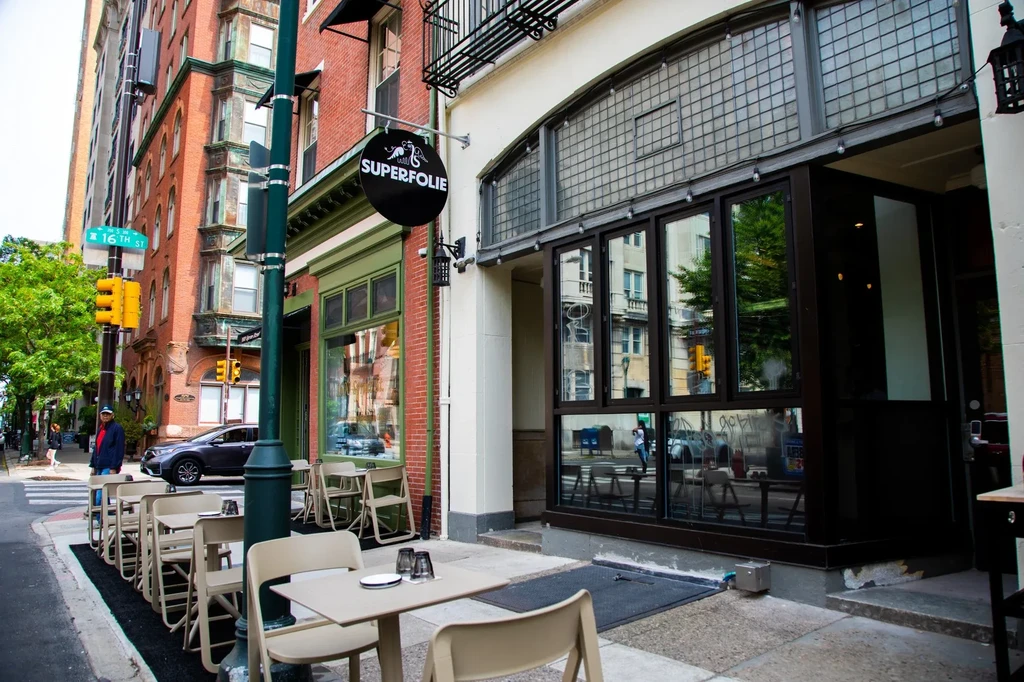SUPERFOLIE restaurant exterior, multi-story brick building, with sidewalk dining.