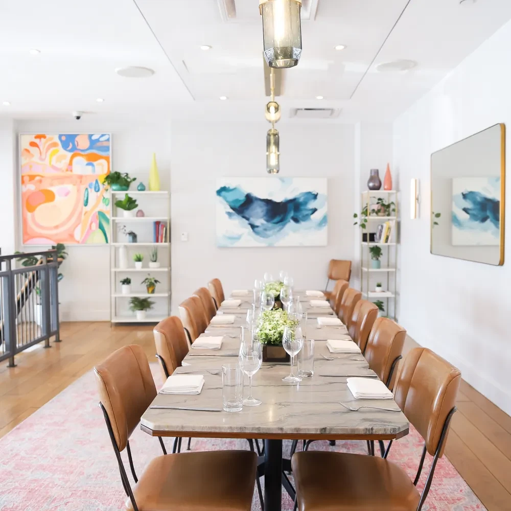 Modern dining room with a long set marble table and chairs.