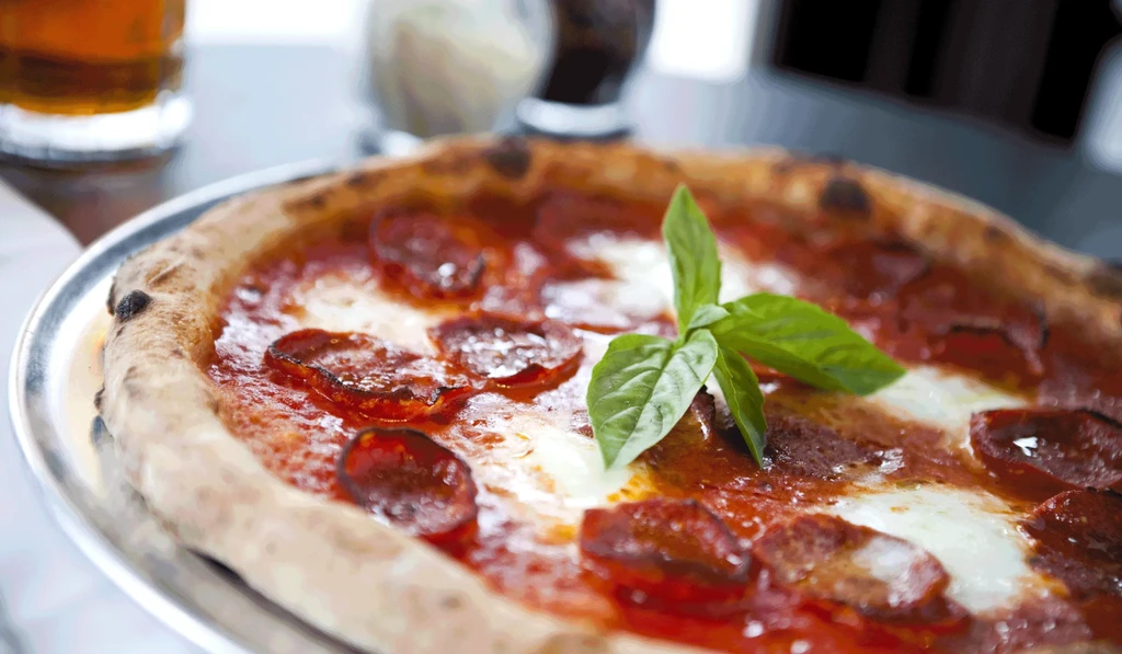 Freshly baked pepperoni pizza with melted cheese, crispy pepperoni, and fresh basil.