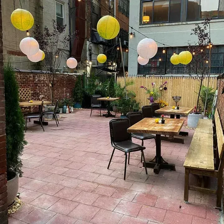 Evening outdoor dining patio with string lights and paper lanterns.