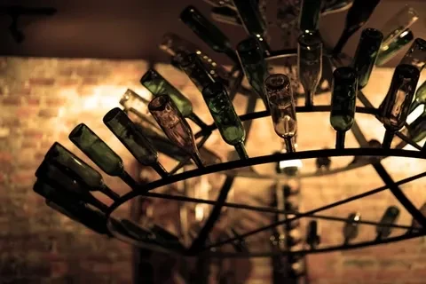 Multi-tiered chandelier crafted from green and brown wine bottles.