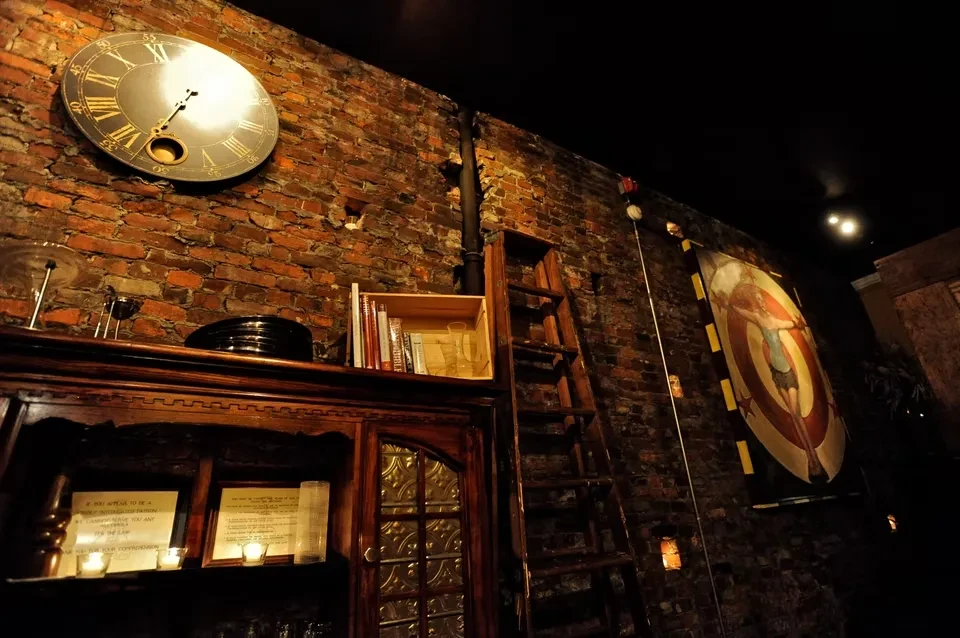 Rustic interior with brick wall, antique clock, candlelit hutch, and banner.