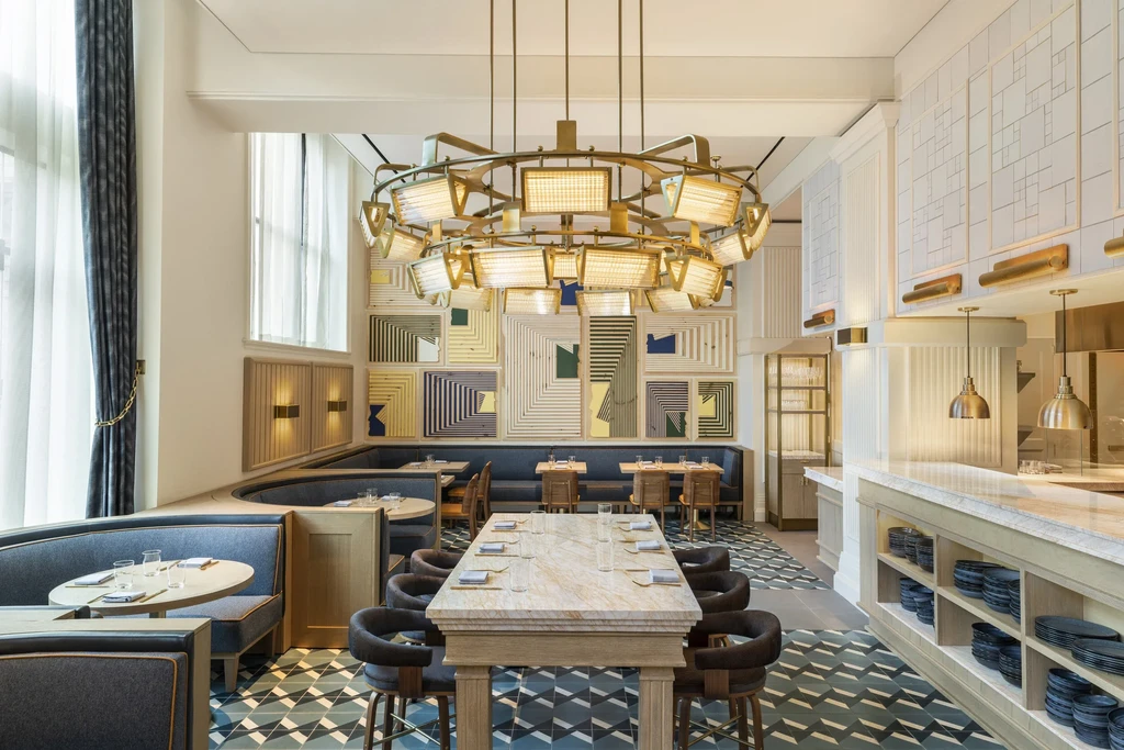 Elegant, modern restaurant interior with chandelier, diverse seating, and art.