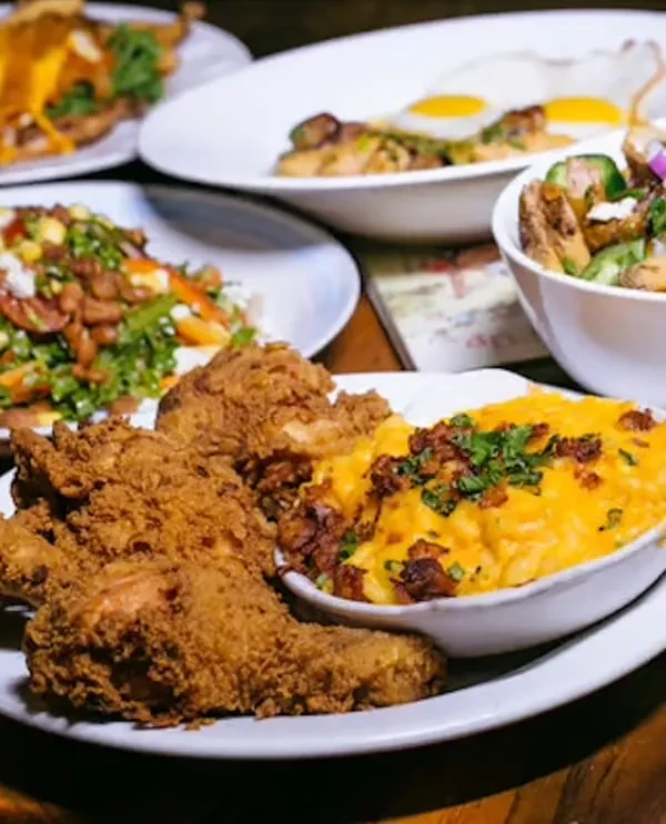 Fried chicken, mac and cheese with bacon, and a spread of food.