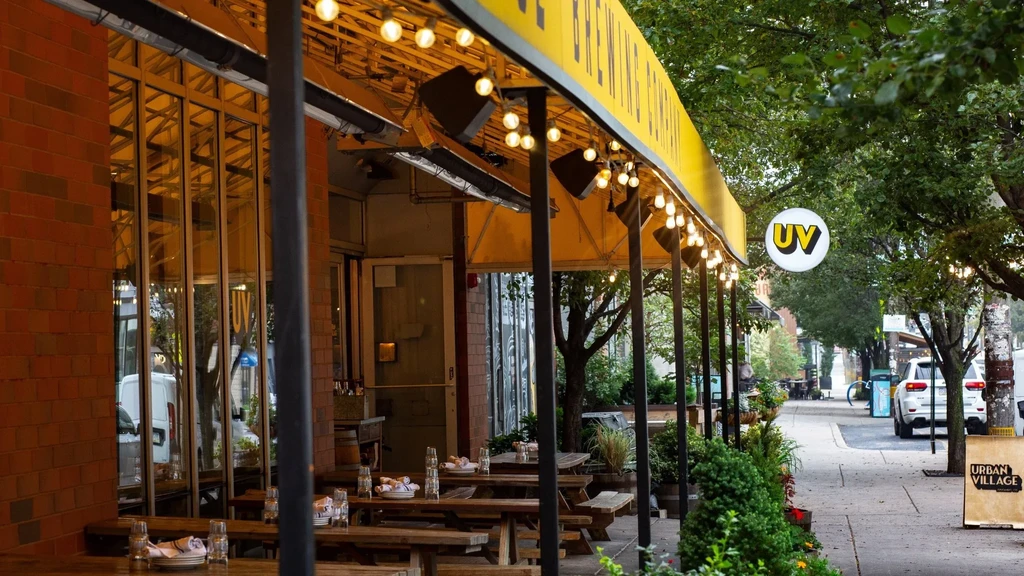Urban Village restaurant patio at dusk, well-lit with tables set.