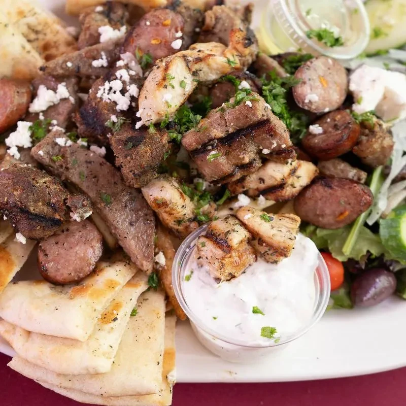 Generous Greek platter: grilled meats, feta, pita, tzatziki, and salad.