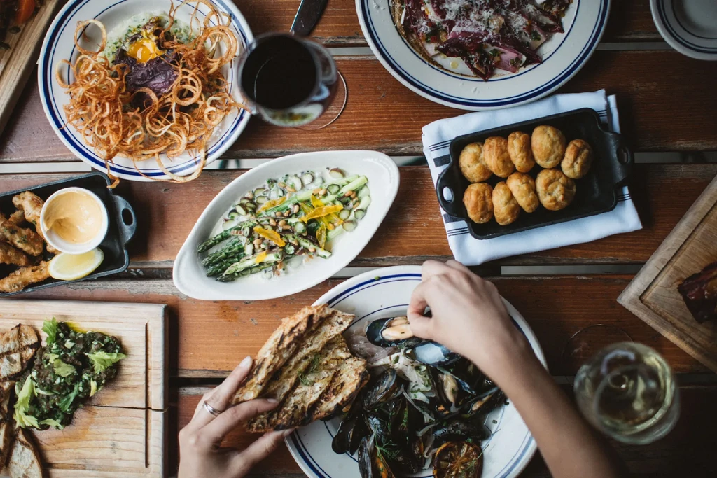 Rustic dining table, top-down view, with varied artfully presented dishes.
