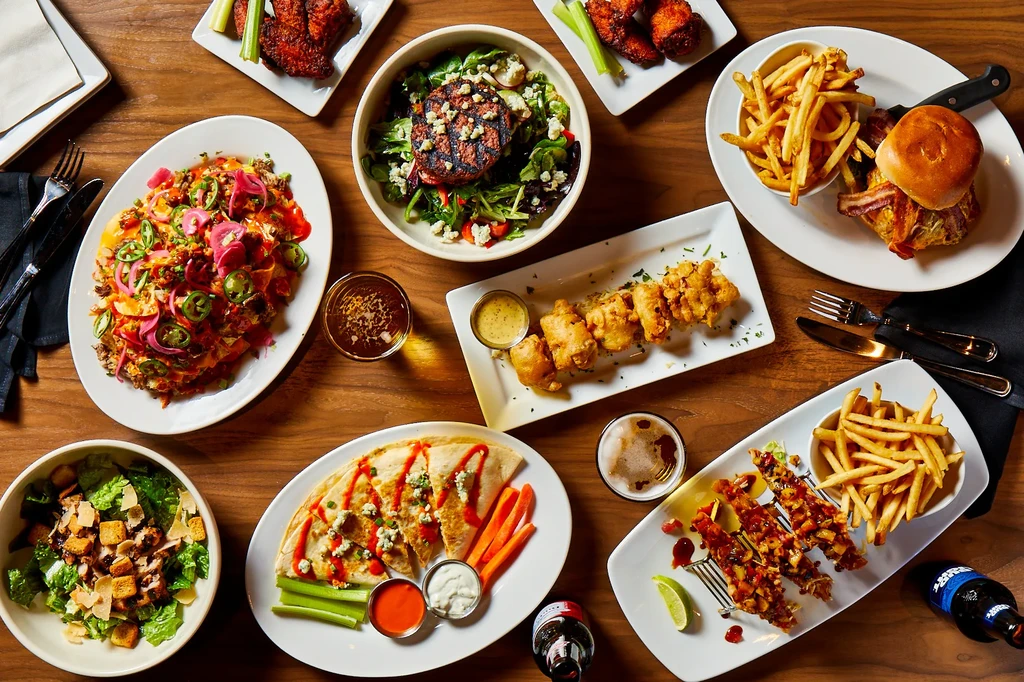 Table from above with various restaurant dishes, beer, and drinks.