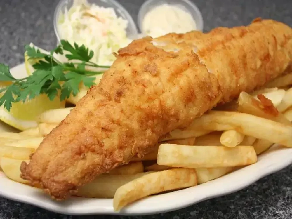 Classic fish and chips with lemon, parsley, and sauces.