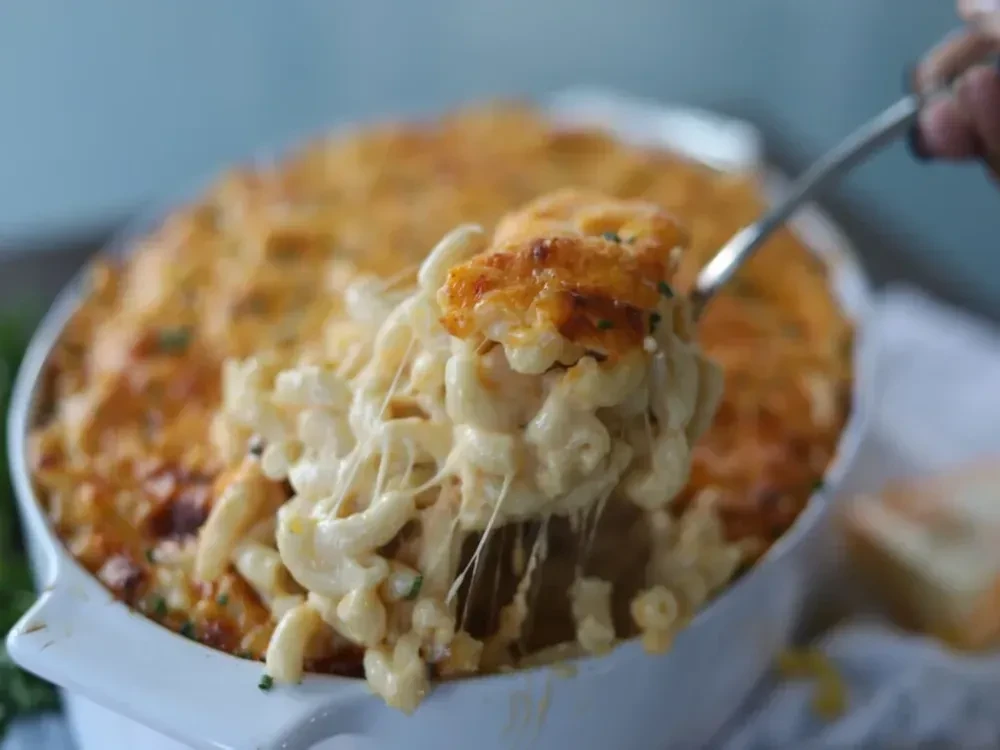 A spoon lifts stringy, bubbly, baked mac and cheese.