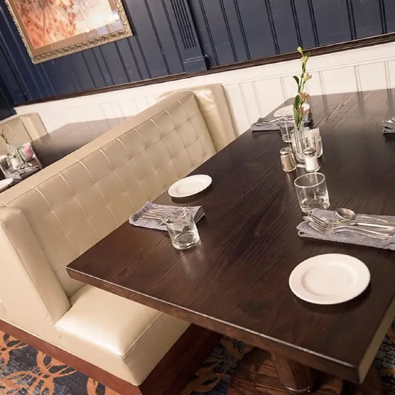 Elegant restaurant interior with a beige booth and set table.