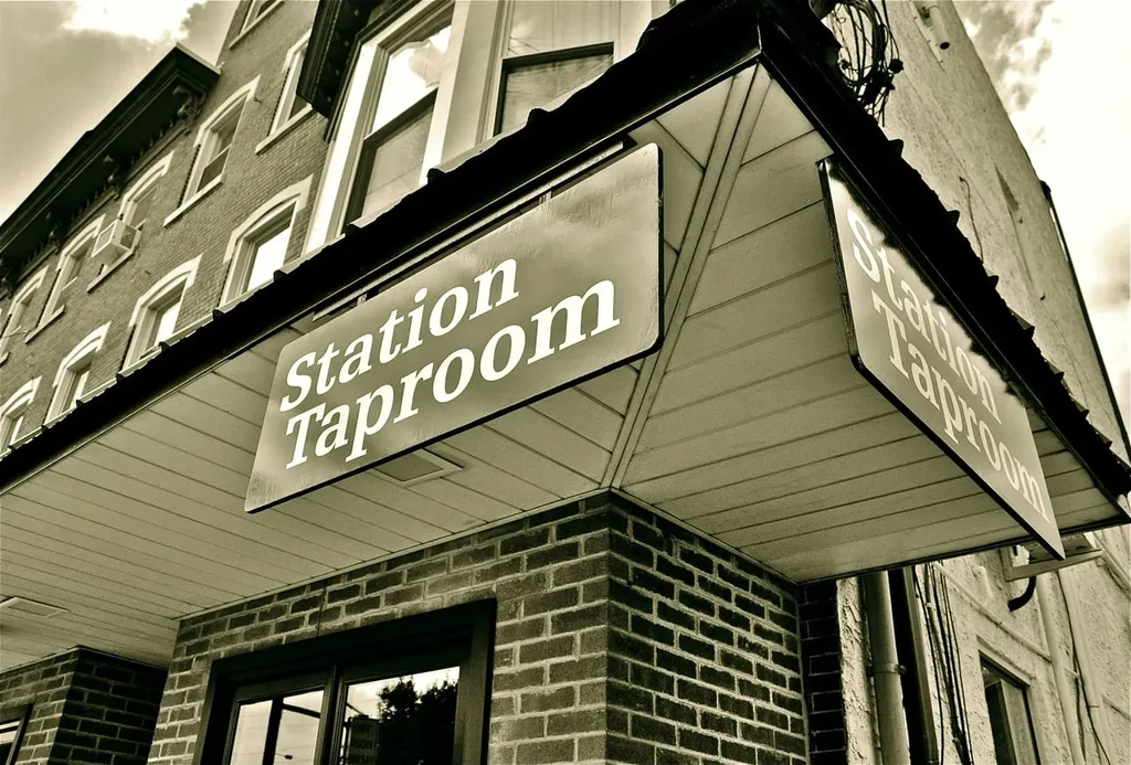 Vintage-toned brick building corner with a "Station Taproom" sign.