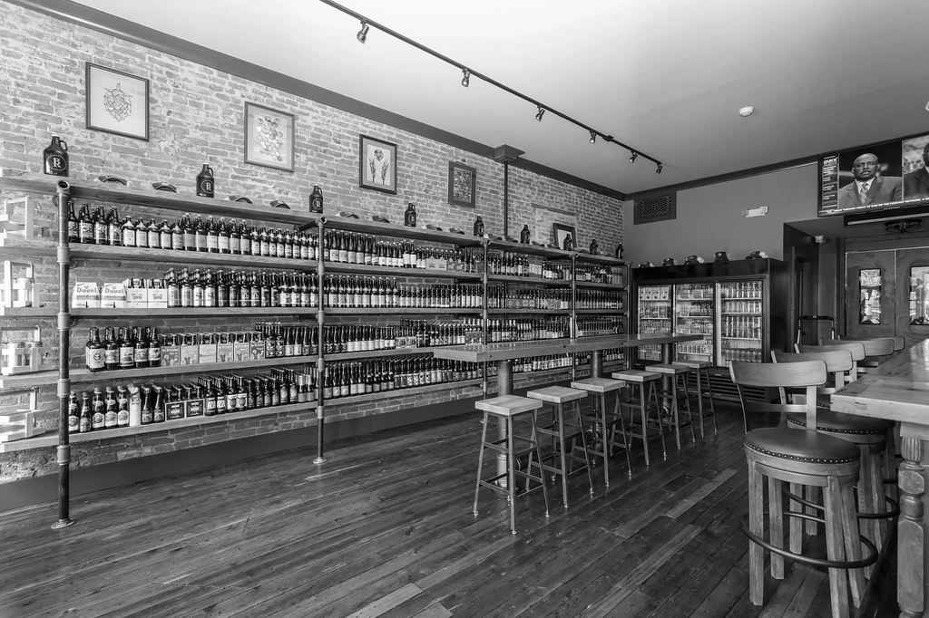 Black and white industrial-rustic craft beer bar with bottles.