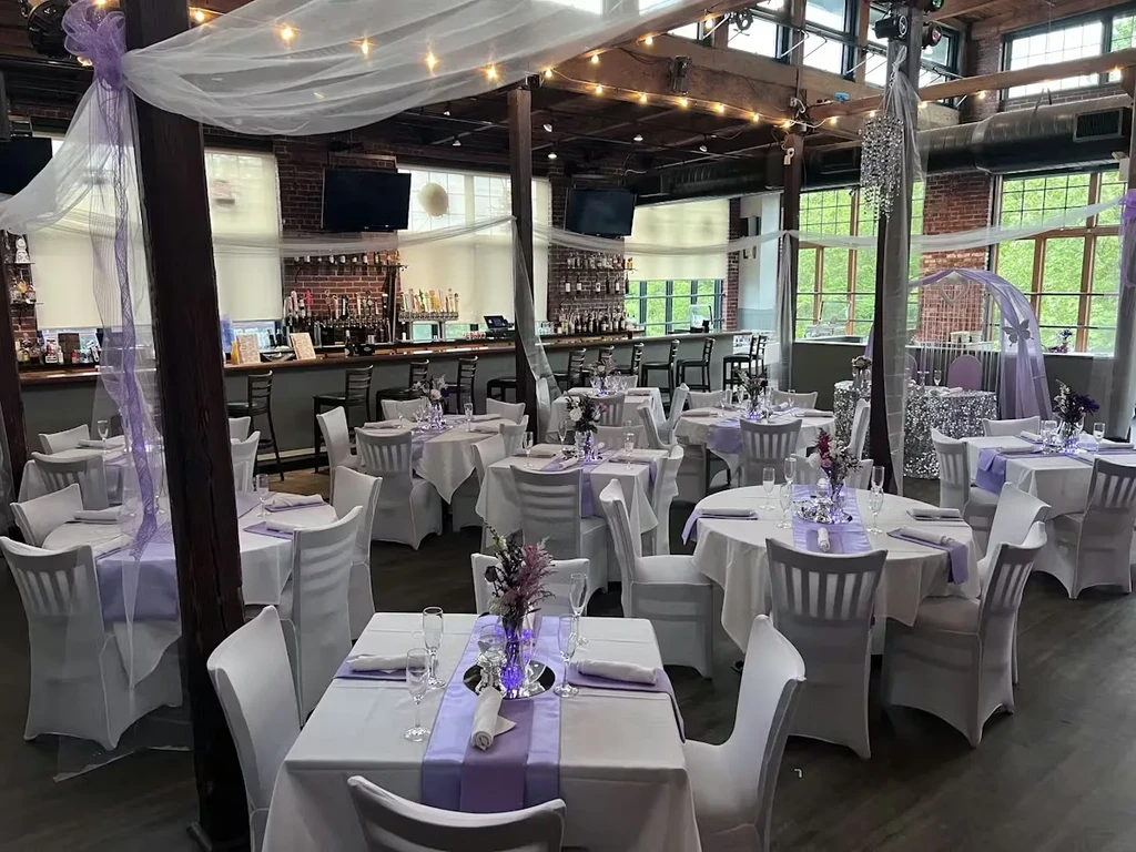 Industrial-chic event space with white and lavender wedding decor.