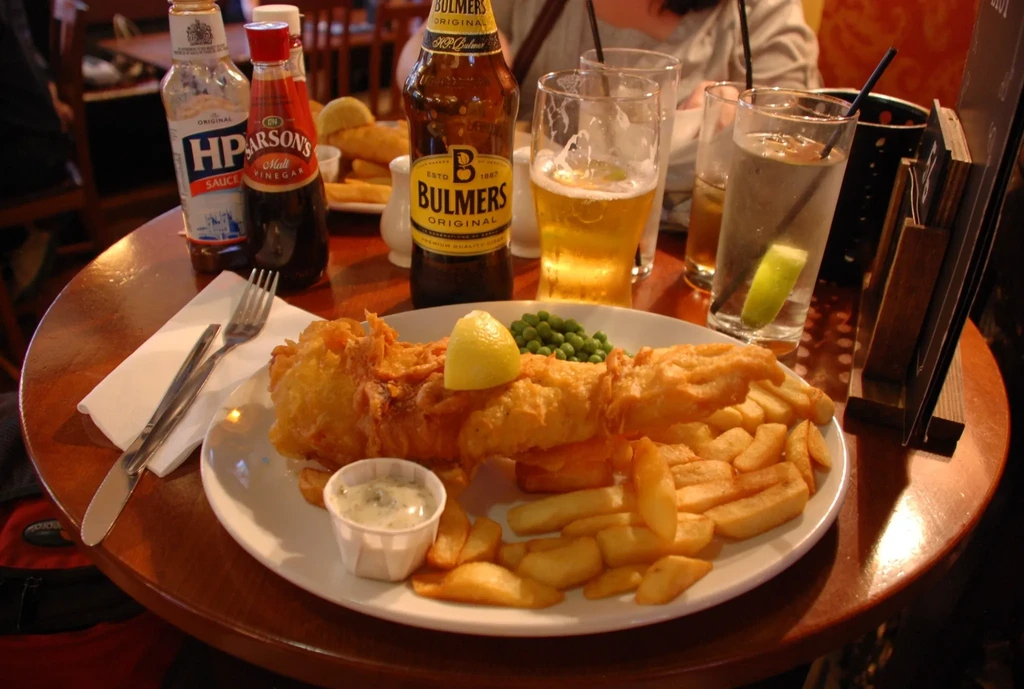 Classic pub fish and chips with cider, beer, and condiments.