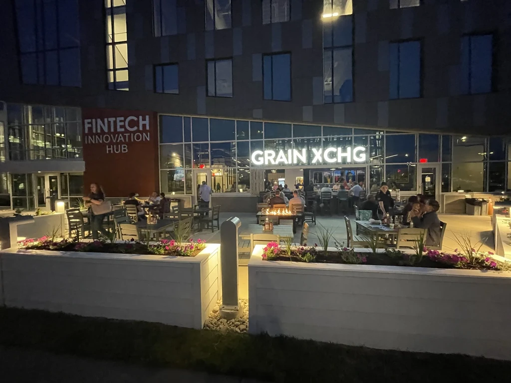 GRAIN XCHG bar exterior with busy patio and fire pit at dusk.