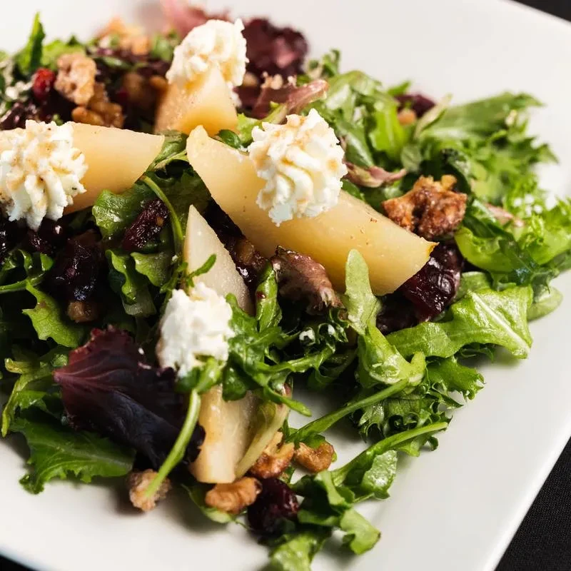 Fresh salad with pear, whipped goat cheese, mixed greens, and nuts.