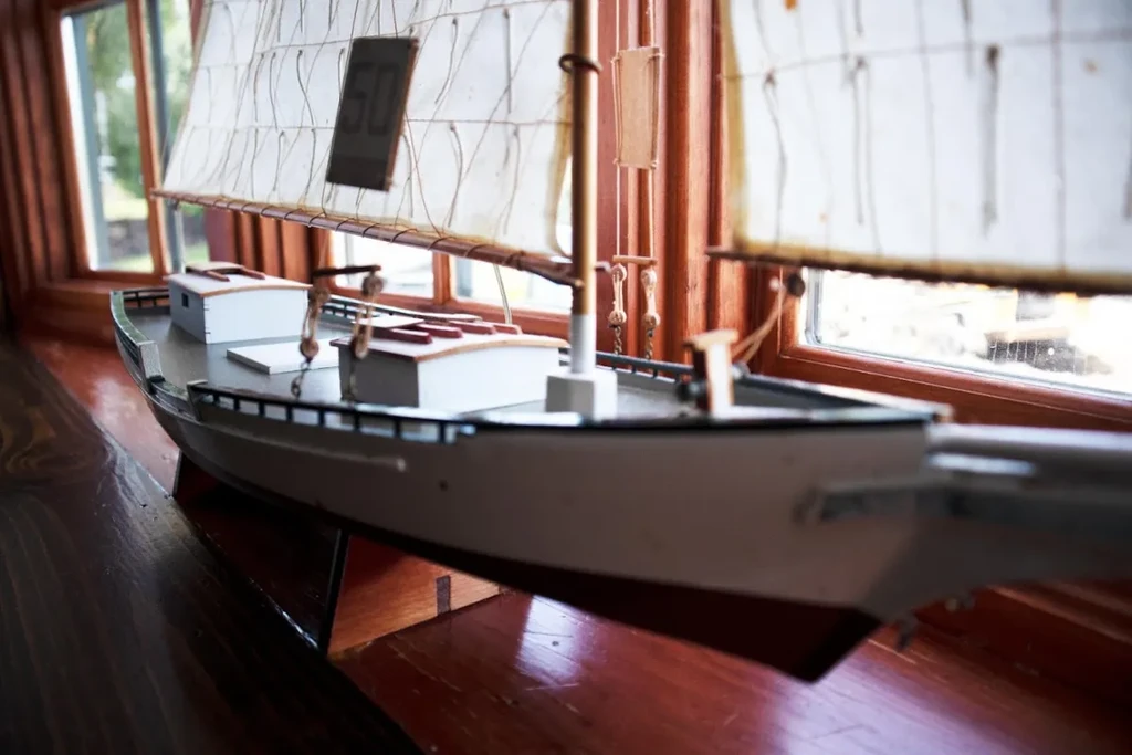 Detailed model sailboat with '50' on translucent sail, on wood.