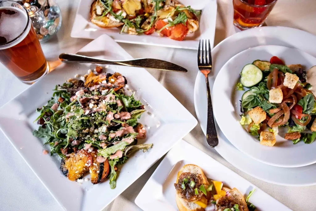 Overhead shot: various colorful dishes and drinks on a white tablecloth.