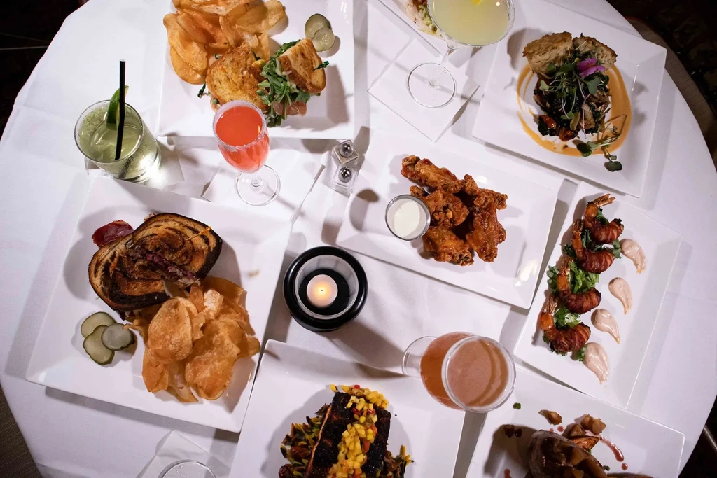 Overhead shot of a round table laden with diverse food and drinks.