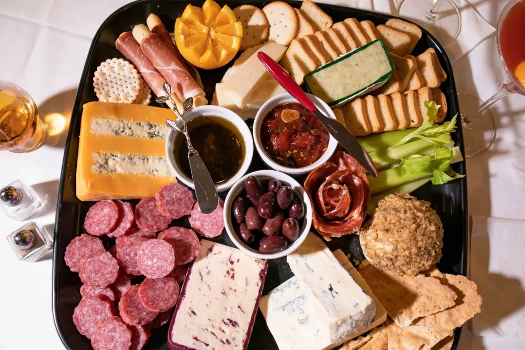 Overhead view of a large, overflowing charcuterie and cheese board.