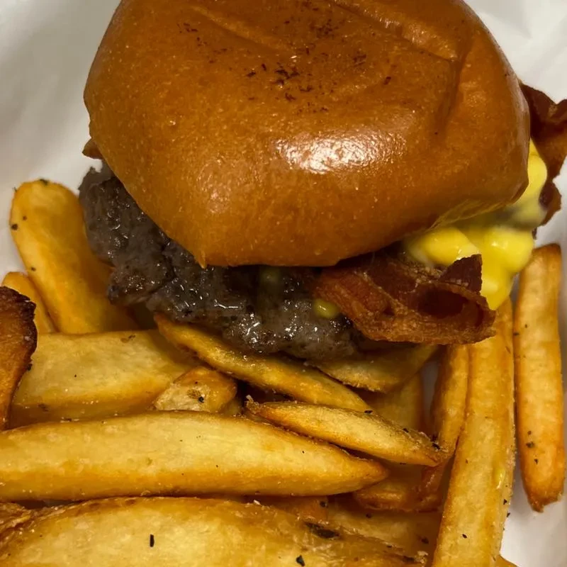 Burger with cheese and bacon, served with seasoned wedge fries.
