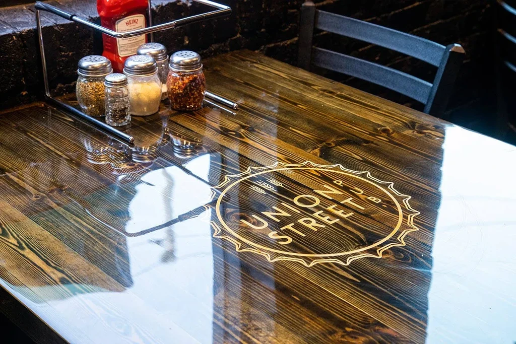 Glossy pub table with condiment caddy and embedded Union Street Pub logo.