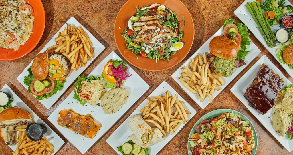 Overhead shot of many diverse restaurant dishes on a table.