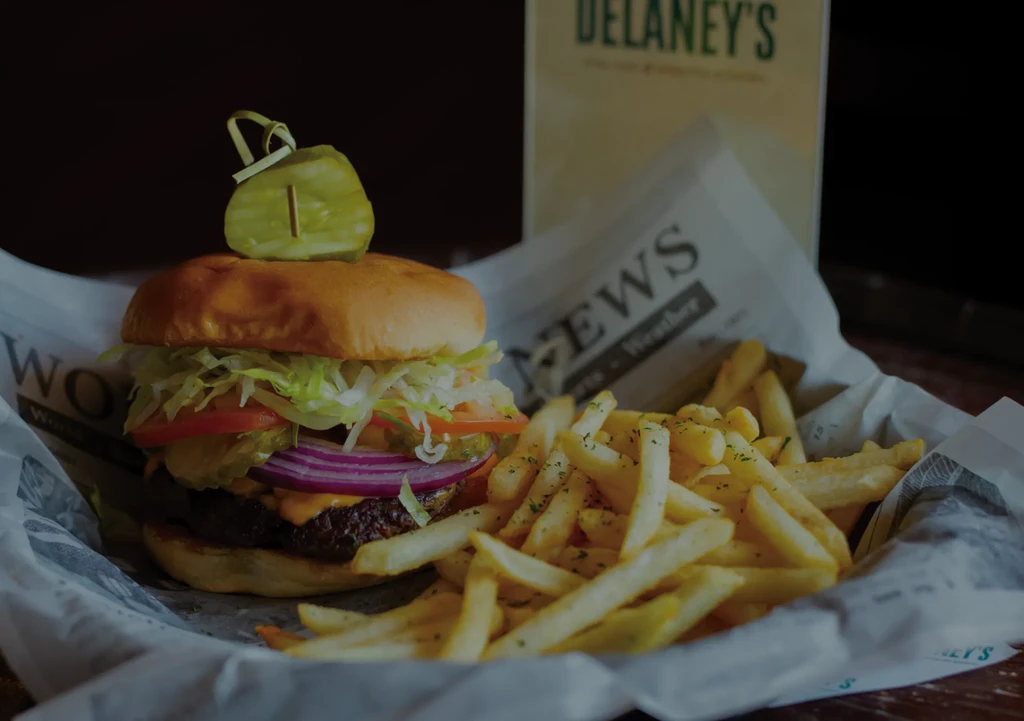 Cheeseburger with melted cheese and crispy French fries in a basket.