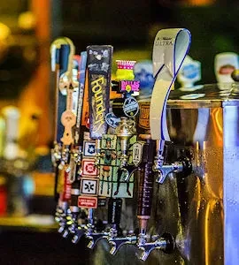 Close-up of distinct beer tap handles on a polished bar system.
