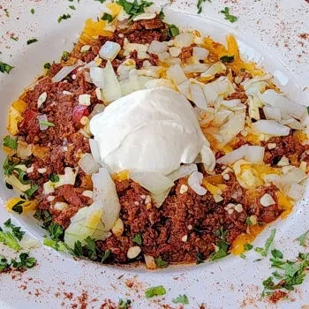 Ground beef chili with cheese, onions, sour cream, almonds, and herbs.