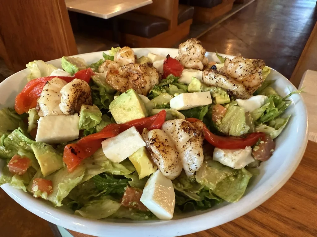 Grilled shrimp salad with avocado, cheese, lettuce, and bell pepper.