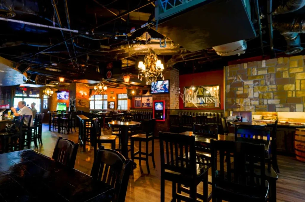 Cozy, industrial-rustic pub interior with sports TVs and Halloween decor.