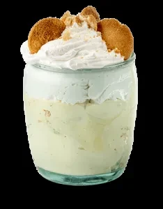 Layered pudding in a glass jar with whipped cream and vanilla wafers.