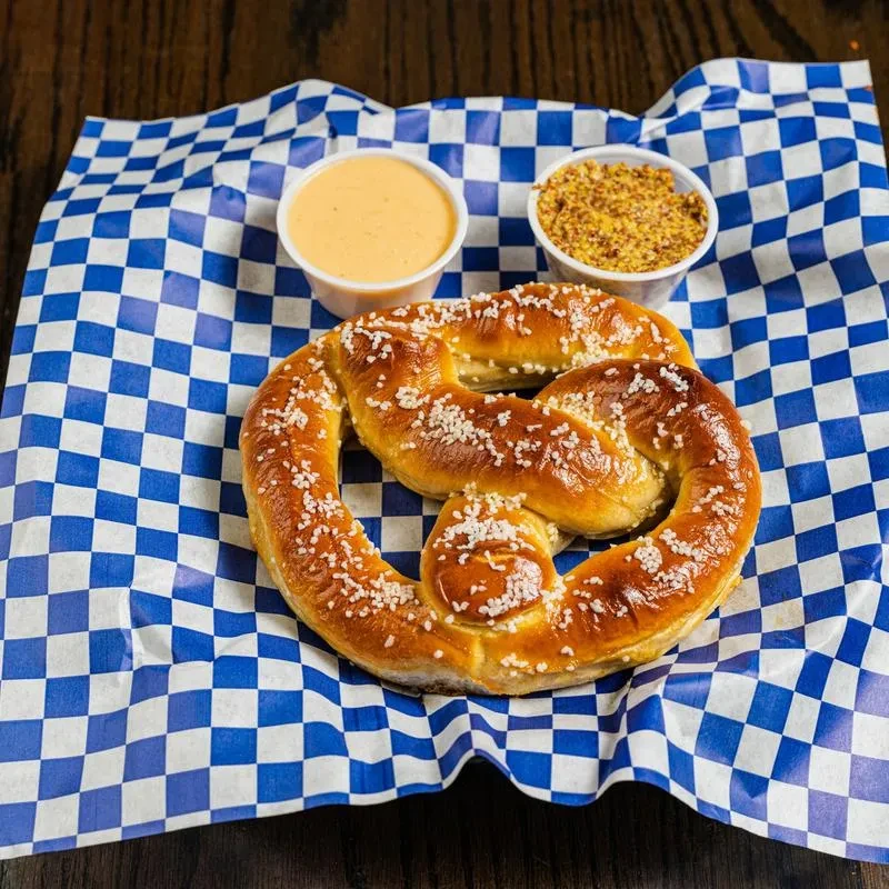 Salted golden-brown pretzel with creamy orange sauce and whole-grain mustard.