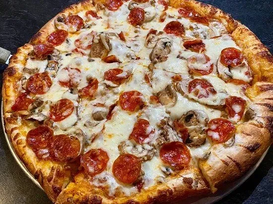A thick-crust pepperoni and mushroom pizza on a metallic pan.