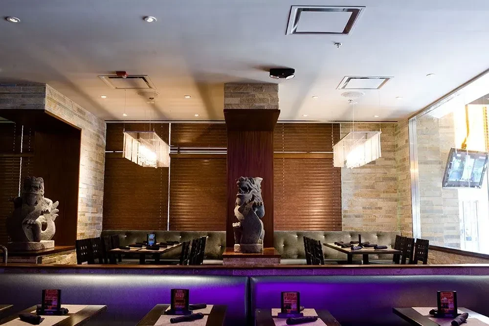 Modern restaurant with purple LED strip lighting and tufted booths.