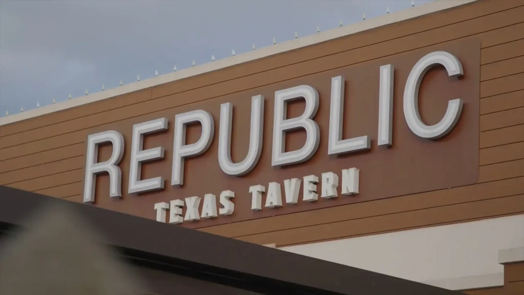 White raised-letter 'REPUBLIC TEXAS TAVERN' sign on brown building.