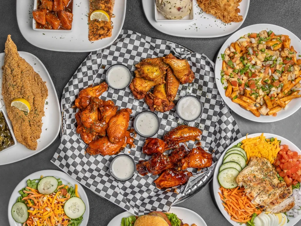 A variety of restaurant meals, including chicken, fish, salads, and loaded fries.